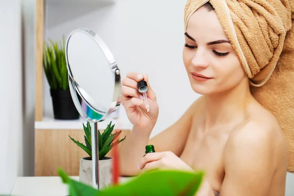 Mooie vrouw aanbrengen make-up op gezicht in huis — Stockfoto