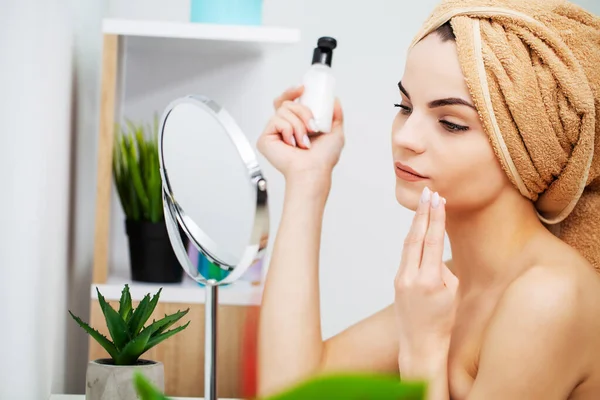 Wanita cantik menerapkan makeup di wajah di rumah — Stok Foto