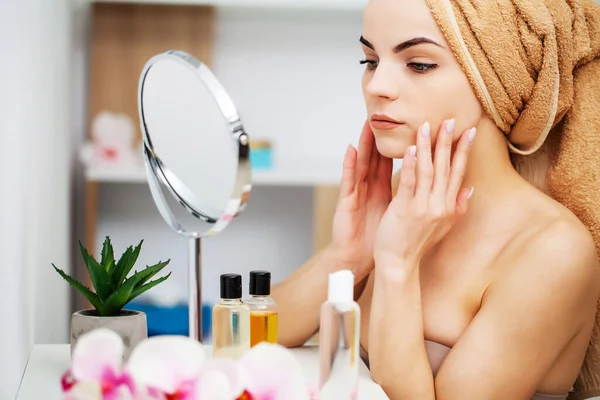 Mooie vrouw aanbrengen make-up op gezicht in huis — Stockfoto