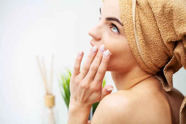 Wanita cantik menerapkan makeup di wajah di rumah — Stok Foto