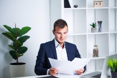 Ceketli sağlam bir işadamı, şirkette çalışan belgelerle çalışıyor..