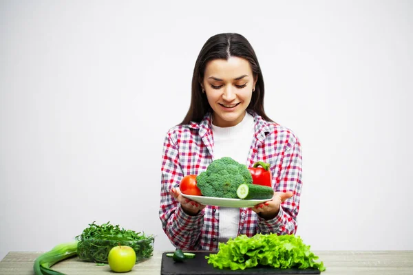 Begreppet hälsosam kost och diet flicka hålla grönsaker på bakgrund vit vägg — Stockfoto