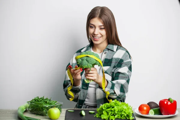 El concepto de alimentación saludable y dieta niña sosteniendo verduras en la pared blanca de fondo — Foto de Stock