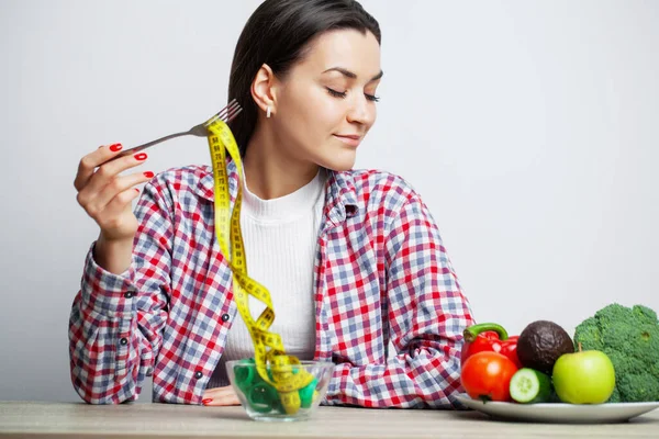 Mujer a dieta sosteniendo un plato lleno de cinta adhesiva . — Foto de Stock