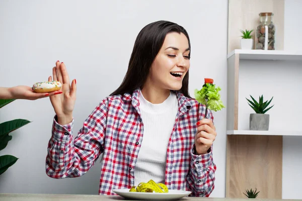 Kvinna gör ett val mellan hälsosam och skadlig mat. — Stockfoto
