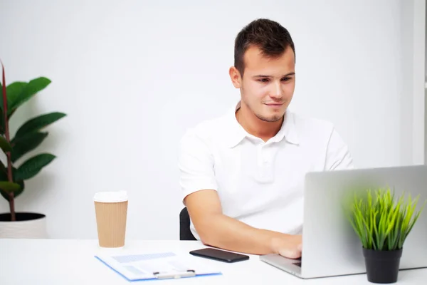 Podnikatel v bílé košili pracuje v kanceláři společnosti na notebooku. — Stock fotografie
