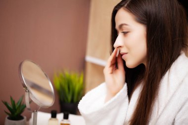 Güzel kız evde aynanın önünde estetik ameliyat yapıyor.