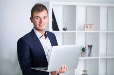 Şirket ofisinde çalışan yakışıklı genç bir işçi. Belgeleri ve bilgisayarı var.