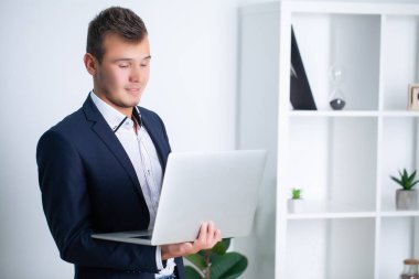 Şirket ofisinde çalışan yakışıklı genç bir işçi. Belgeleri ve bilgisayarı var.