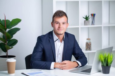 Şirket ofisinde çalışan yakışıklı genç bir işçi. Belgeleri ve bilgisayarı var.