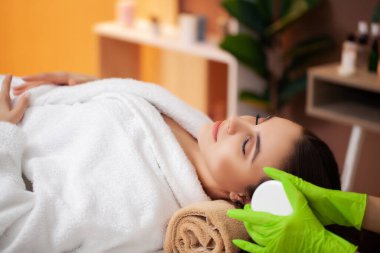Güzel kadın spa salonunda rahatlatıcı bir masaj yaptırıyor.