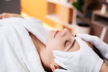 Güzel kadın spa salonunda rahatlatıcı bir masaj yaptırıyor.