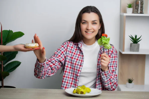 Vacker kvinna som gör ett val mellan nyttig och skadlig mat — Stockfoto