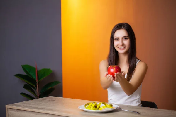 Mulher bonita que faz uma escolha entre alimentos úteis e prejudiciais — Fotografia de Stock