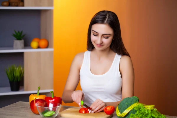 Joven hermosa chica prepara una ensalada de dieta útil . — Foto de Stock