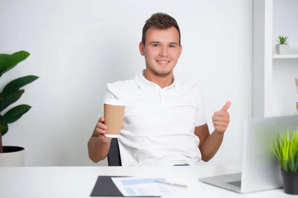 Stilig ung arbetare som arbetar på ett företag kontor med dokument och en bärbar dator — Stockfoto