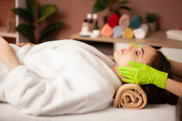 Jolie femme recevant un massage facial dans un salon de spa — Photo