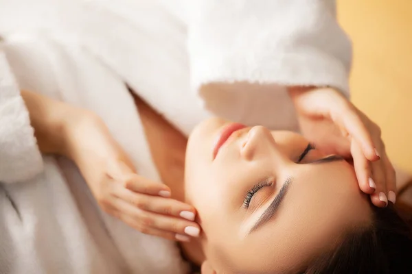 Mujer bonita recibiendo masaje facial en el salón de spa —  Fotos de Stock