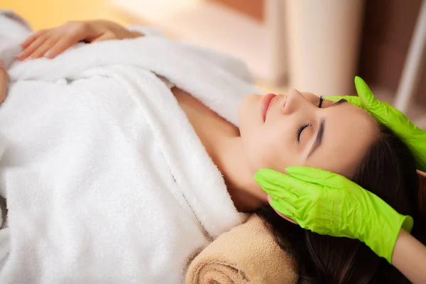 Ładna kobieta otrzymywać masaż twarzy w salonie spa — Zdjęcie stockowe