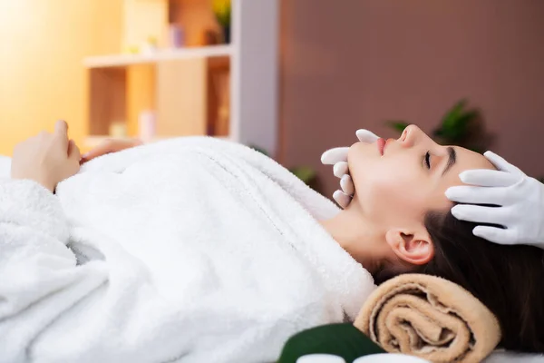 Mujer bonita recibiendo masaje facial en el salón de spa — Foto de Stock