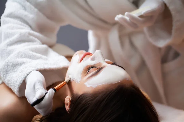 Bella donna che applica maschera al salone spa — Foto Stock