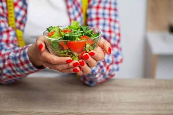 Жінка тримає свіжий овочевий салат у прозорій тарілці — стокове фото