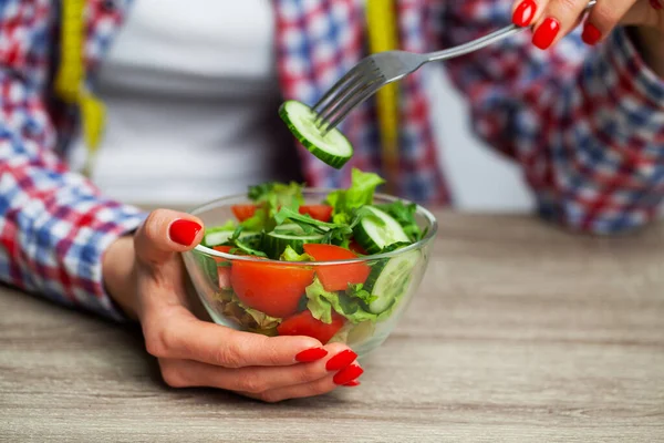 Frau hält frischen Gemüsesalat in einem transparenten Teller — Stockfoto