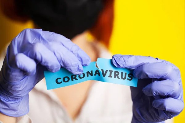 Koruyucu eldivenli bir kadın elinde kutsal koronavirüs tutuyor. — Stok fotoğraf