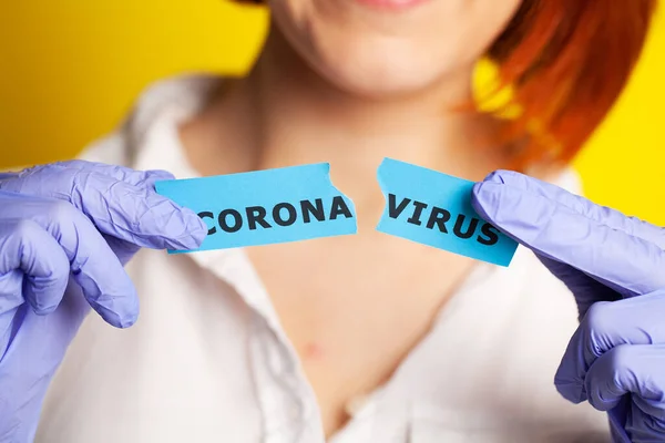 Mujer con guantes protectores con inscripción coronavirus — Foto de Stock
