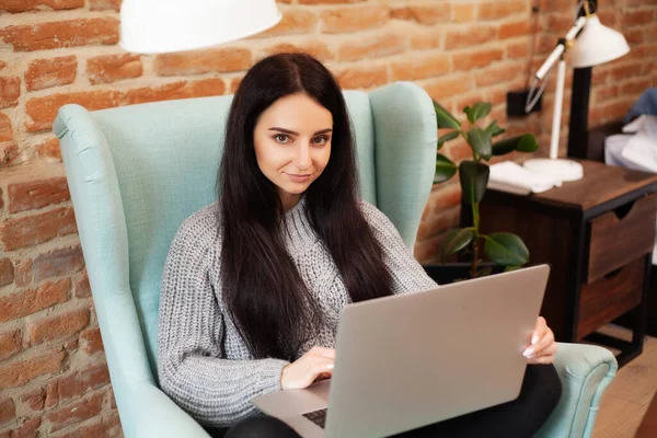 Cute woman stay at home and working at laptop