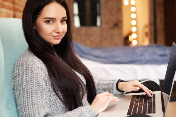 Cute woman stay at home and working at laptop