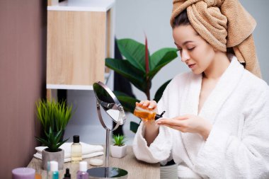 Banyoda cilt bakımı için estetik ameliyat yapan hoş bir kadın.