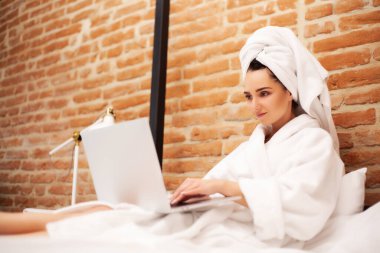 Sevimli kadın evde kalıp dizüstü bilgisayarda çalışıyor.