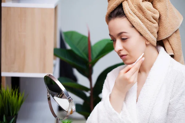 Linda mujer en el baño haciendo procedimiento cosmético para el cuidado de la piel facial — Foto de Stock