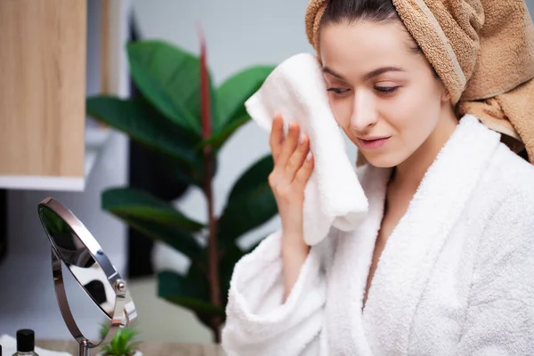 Roztomilá žena v koupelně si utírá obličej po sprše s froté ručníkem — Stock fotografie