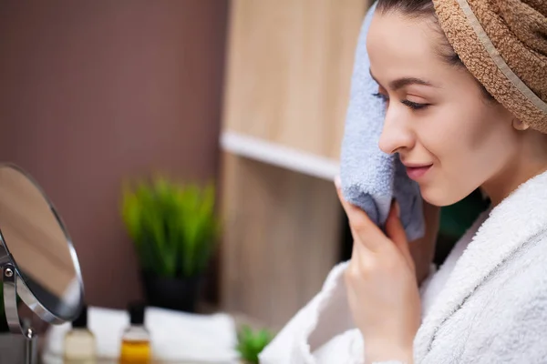 Mujer linda en el baño se limpia la cara después de una ducha con una toalla de rizo — Foto de Stock