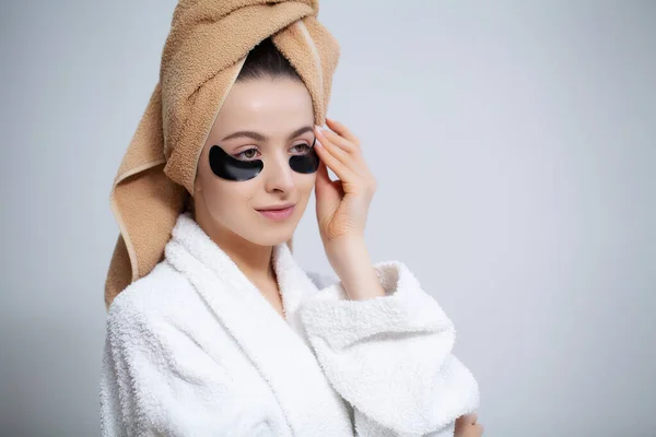 Linda mujer en el baño utilizar parches para el cuidado de la piel facial —  Fotos de Stock