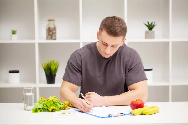 Trainer draws up a training program and a healthy diet plan — Stock Photo, Image