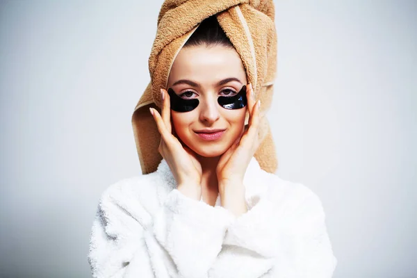 Nette Frau im Badezimmer verwendet Pflaster für die Gesichtspflege. — Stockfoto