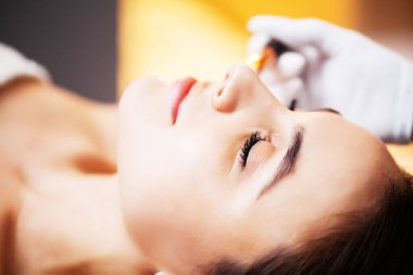 Güzellik stüdyosunda kaplıca maskesi takan bir kadın..