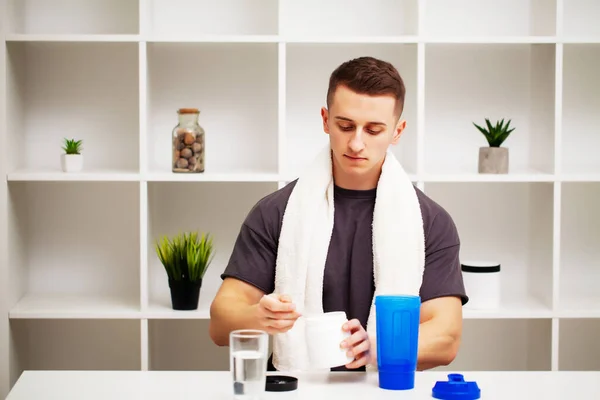 Trainer prepares a protein shake in the shaker after training.