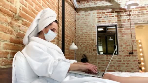 女は伝染病の最中家にいてノートパソコンで働いてる. — ストック動画