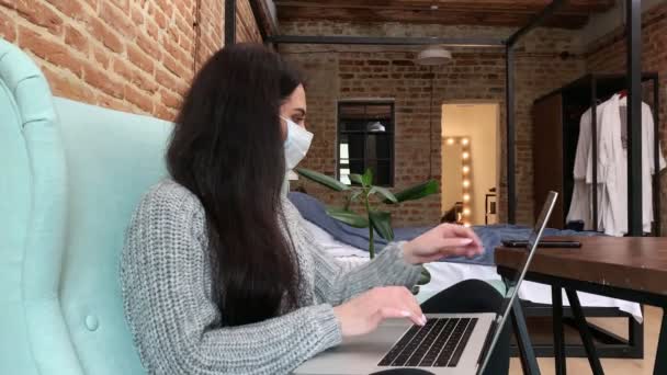 Kvinna stanna hemma under en epidemi och arbetar på en bärbar dator. — Stockvideo