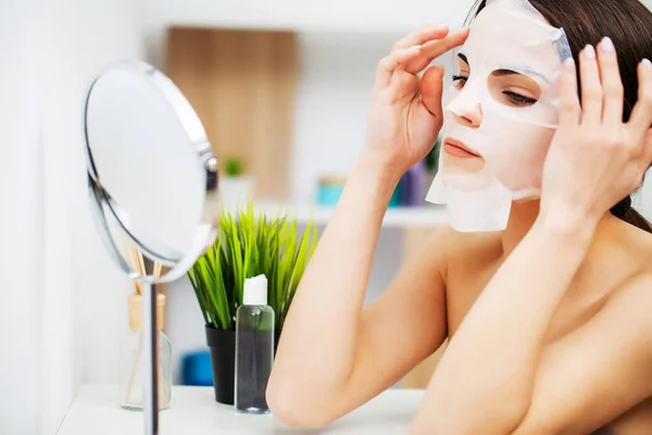 Wanita di kamar mandi menerapkan kosmetik untuk perawatan kulit — Stok Foto