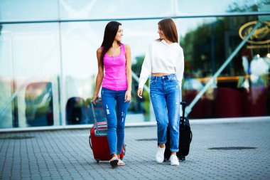 Pretty women who like to travel with suitcases near the airport clipart