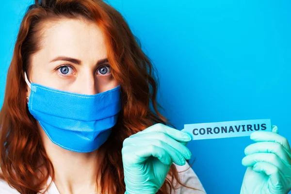 Mujer con máscara y guantes protectores con inscripción coronavirus — Foto de Stock