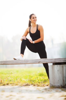 Güzel bir kadın dışarıda spor yapıyor.