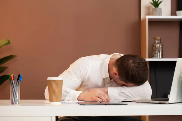 Tired employee working at desk at company office — Stock Photo, Image