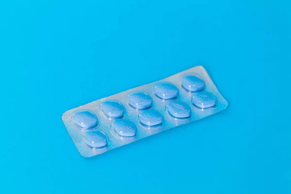 Pillole che promuovono la salute sessuale per gli uomini per lungo tempo su sfondo blu — Foto Stock