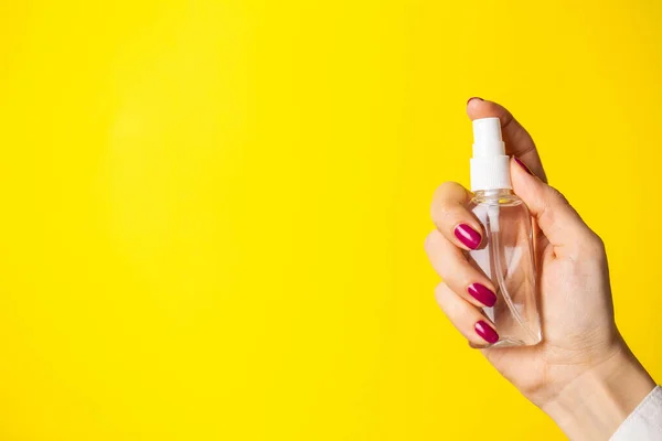 Nő használ kéz fertőtlenítő sárga háttér — Stock Fotó